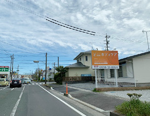 そのすぐ手前の右手にあるオレンジ色の看板が目印です。